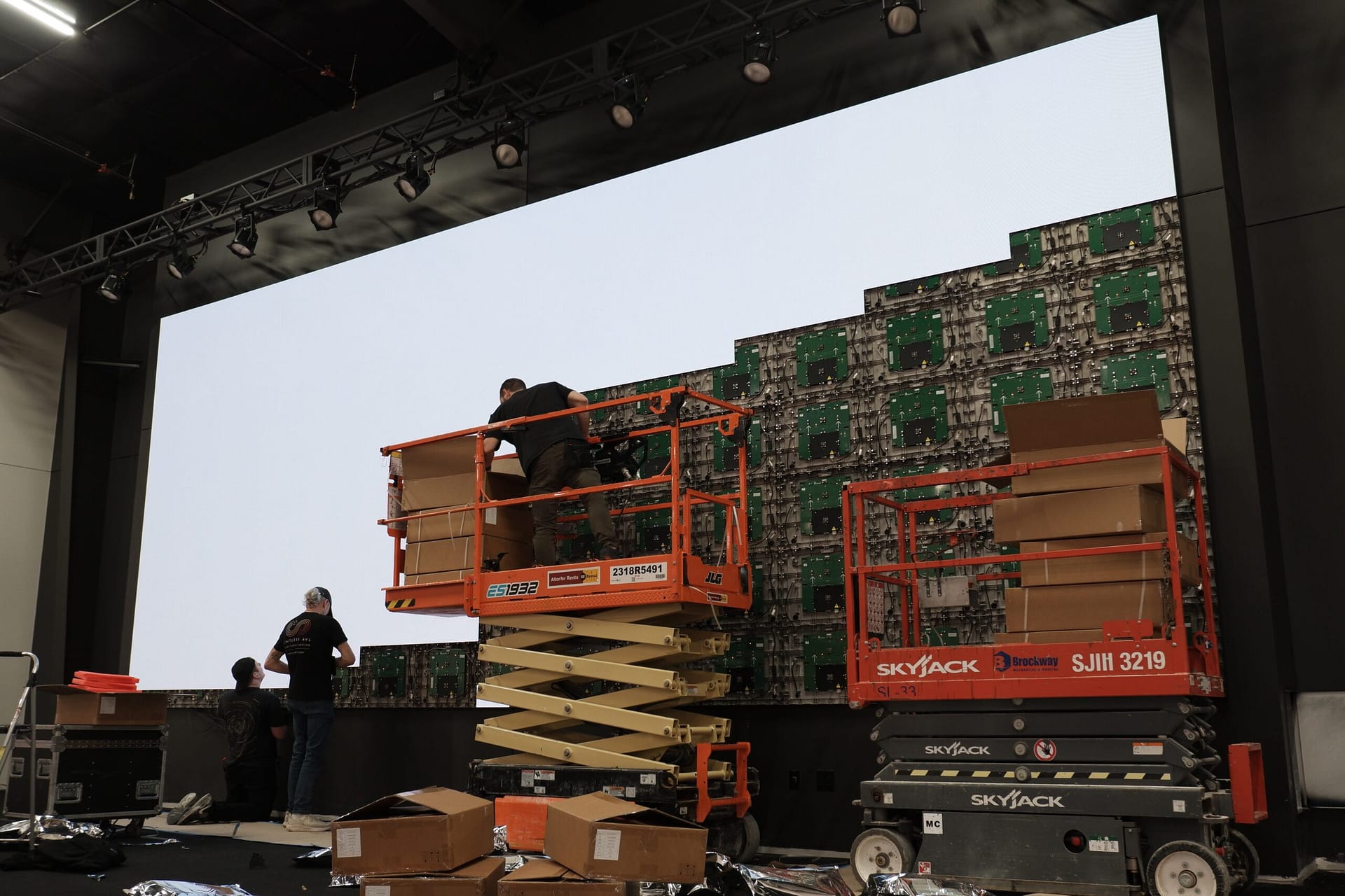 Harmony Bible Church stage during LED wall installation with a scissor lift raised beside the partially built wall